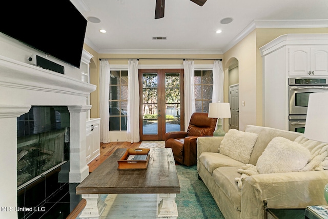 living room featuring dark wood-type flooring, crown molding, french doors, and ceiling fan