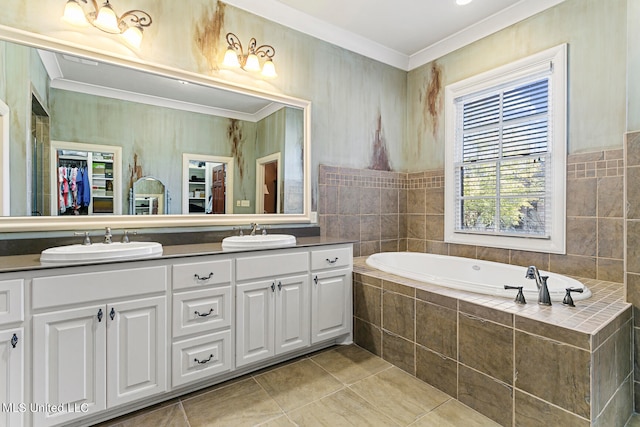 bathroom featuring tile walls, tiled tub, vanity, crown molding, and tile patterned flooring