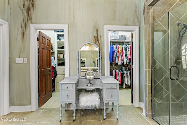 interior space with tile patterned floors and a shower with shower door