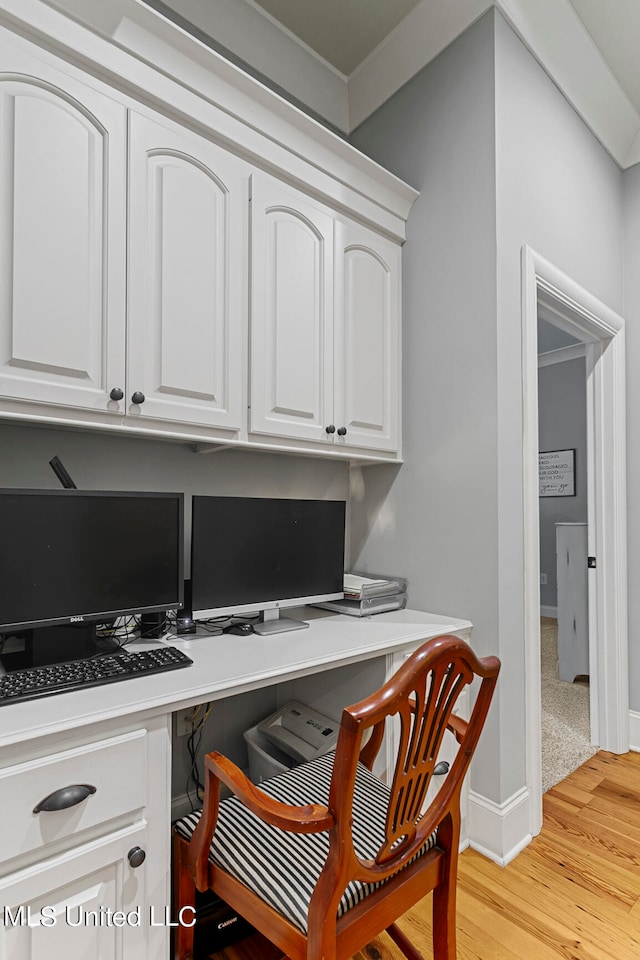 home office featuring built in desk and light wood-type flooring