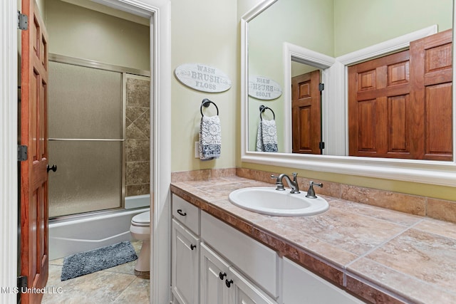 full bathroom with vanity, toilet, and shower / bath combination with glass door