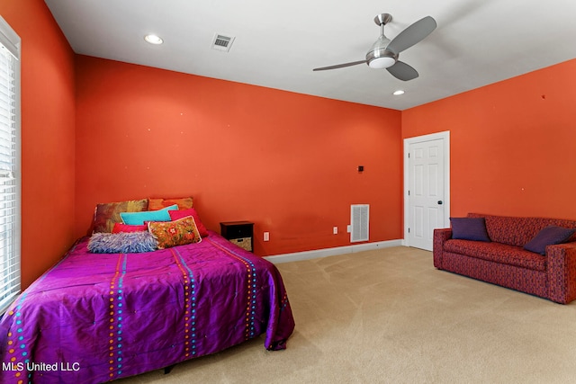 carpeted bedroom featuring multiple windows and ceiling fan