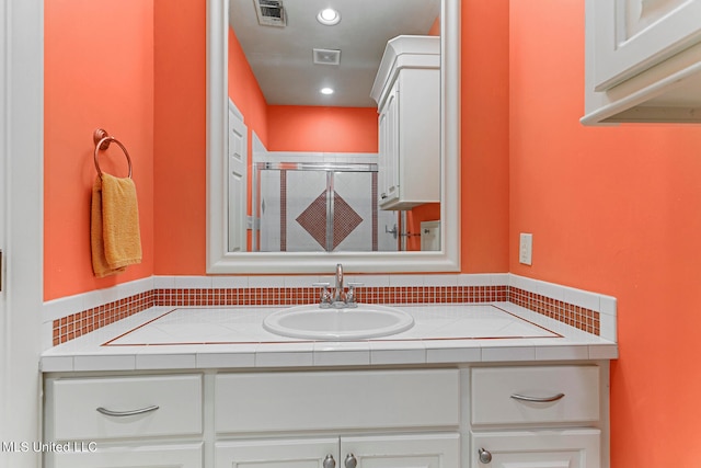 bathroom featuring vanity and a shower with door