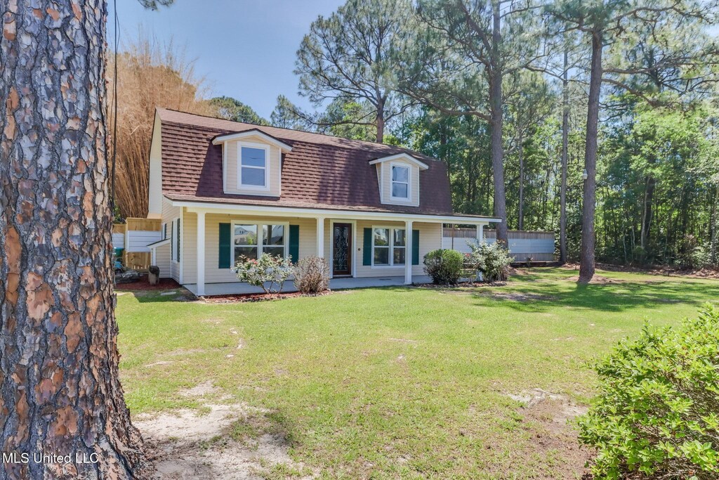 5416 Riley Rd, Ocean Springs, MS 39564 - view of front facade featuring covered porch, a shingled roof, and a front yard