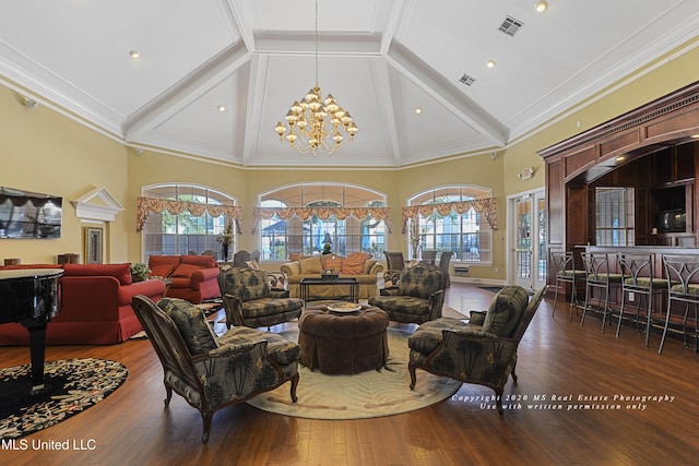 living room with an inviting chandelier, dark hardwood / wood-style floors, high vaulted ceiling, and ornamental molding