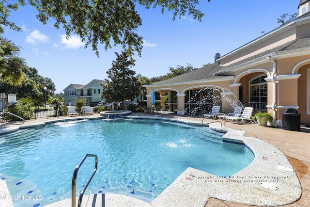 view of pool with pool water feature, a patio, and a hot tub