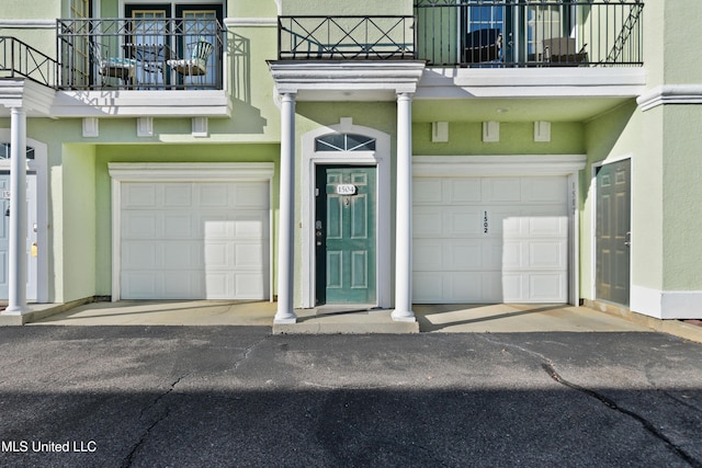 property entrance featuring a balcony and a garage