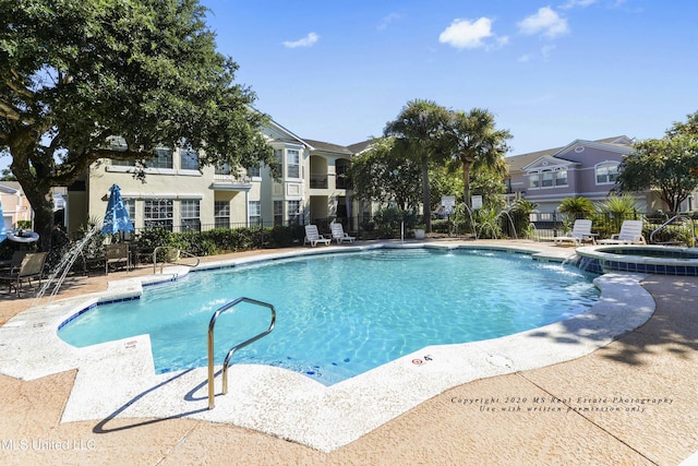 view of swimming pool with a patio area, pool water feature, and a community hot tub