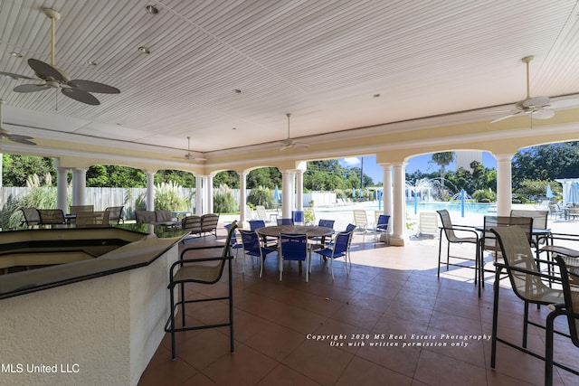 view of patio with a fenced in pool, an outdoor bar, and ceiling fan