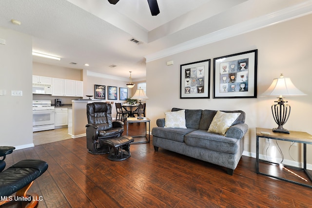 living room featuring ceiling fan, crown molding, and dark wood-type flooring