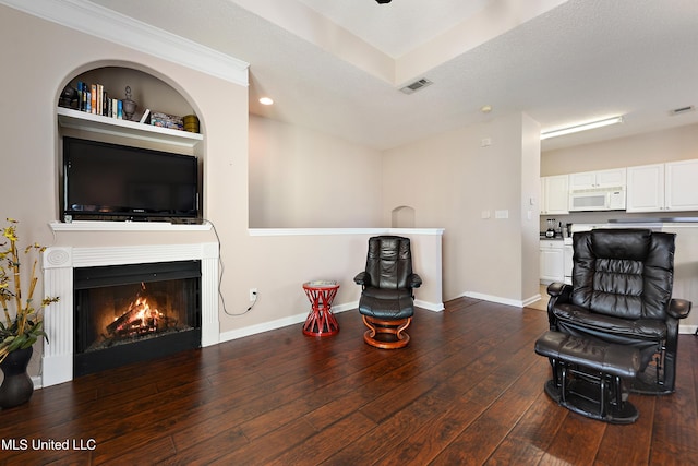 living room with a textured ceiling, built in features, and dark wood-type flooring