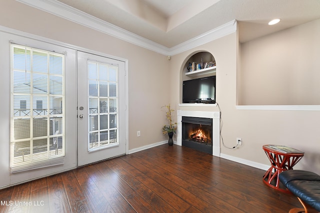 interior space featuring dark hardwood / wood-style flooring, built in features, ornamental molding, and french doors