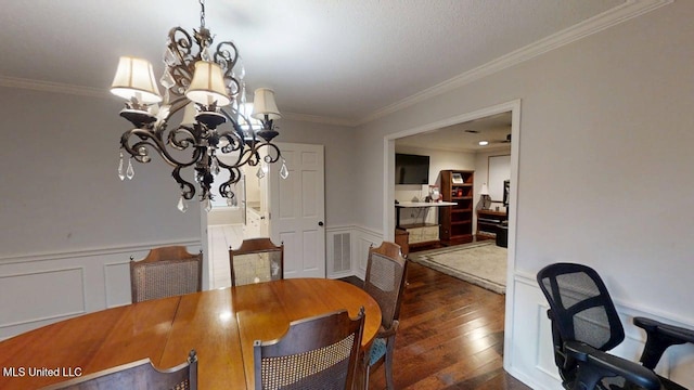 136 Westlake Dr, Brandon, MS 39047 - dining room featuring a chandelier, ornamental molding, hardwood / wood-style flooring, wainscoting, and a decorative wall