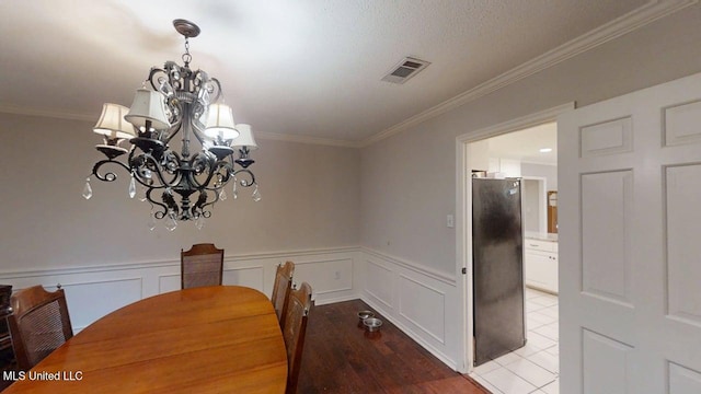 136 Westlake Dr, Brandon, MS 39047 - dining area featuring a chandelier, crown molding, a wainscoted wall, and light wood finished floors