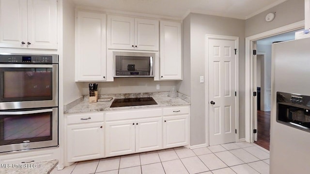 136 Westlake Dr, Brandon, MS 39047 - kitchen with appliances with stainless steel finishes, white cabinetry, light tile patterned floors, light stone counters, and baseboards