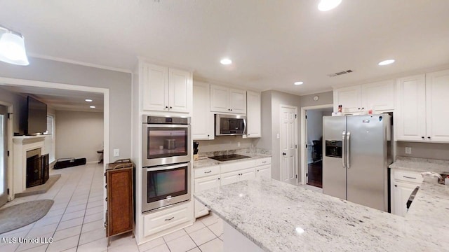 136 Westlake Dr, Brandon, MS 39047 - kitchen featuring stainless steel appliances, white cabinets, light tile patterned floors, light stone counters, and recessed lighting