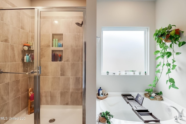 bathroom featuring shower with separate bathtub