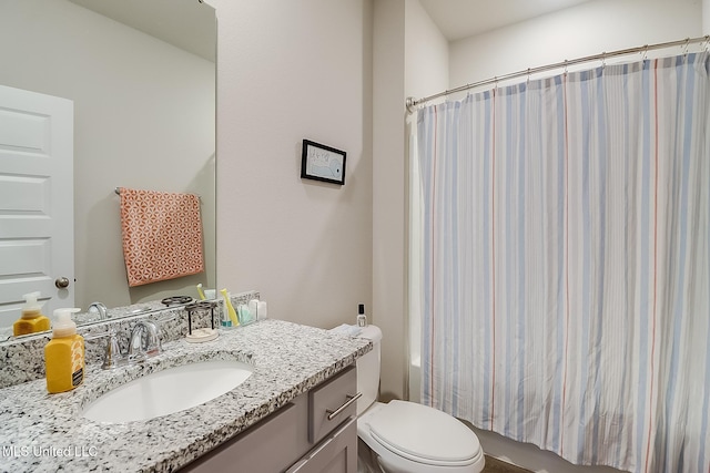 bathroom with walk in shower, vanity, and toilet