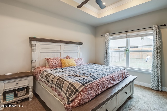 carpeted bedroom with ceiling fan, ornamental molding, and a raised ceiling