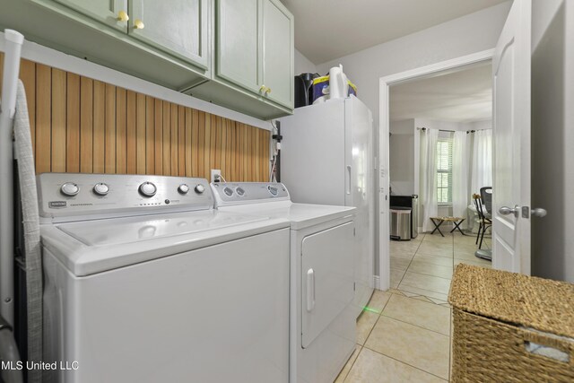22807 Alamosa Dr, Moss Point, MS 39562 - laundry room with cabinet space, light tile patterned floors, and washing machine and dryer