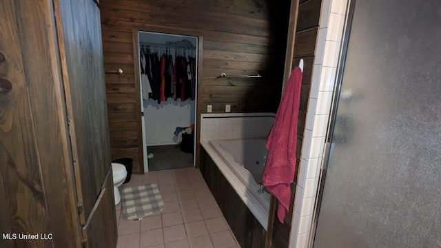 bathroom with plus walk in shower, tile patterned flooring, wood walls, and toilet