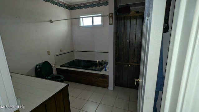 bathroom with toilet, tile patterned flooring, and a washtub