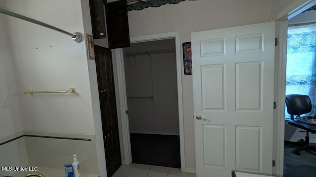 bathroom with tile patterned floors and a washtub