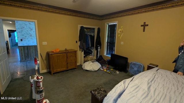 carpeted bedroom featuring ornamental molding and a closet