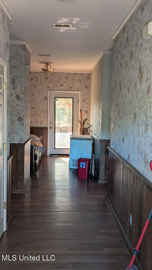 hallway featuring ornamental molding and dark hardwood / wood-style floors