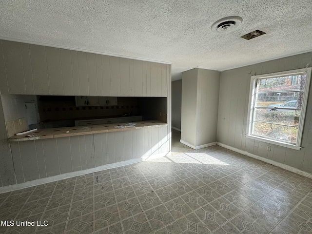 unfurnished living room with wood walls