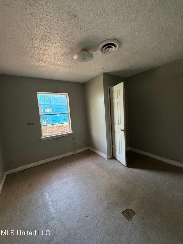 unfurnished room featuring a textured ceiling