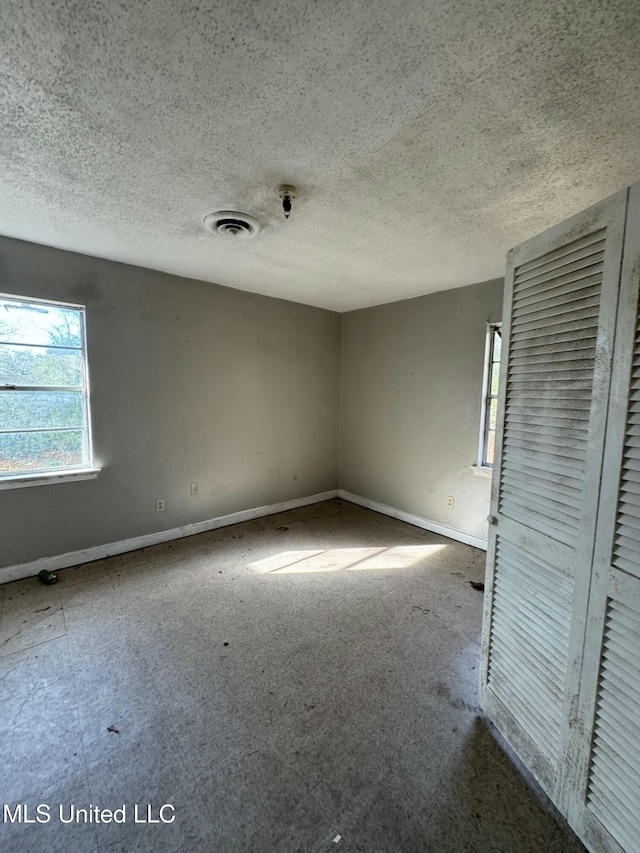 unfurnished room featuring a textured ceiling