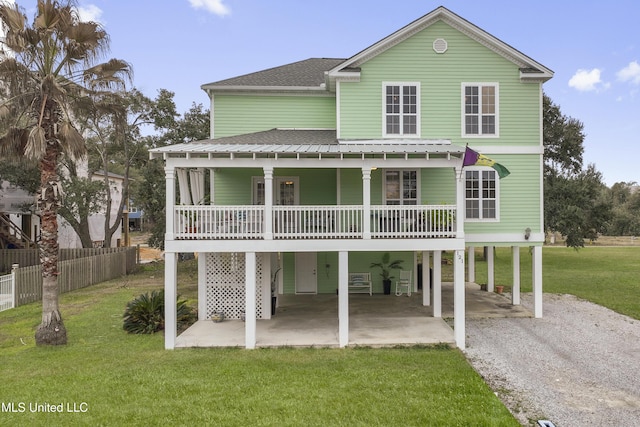 view of front of home with a carport, covered porch, and a front lawn