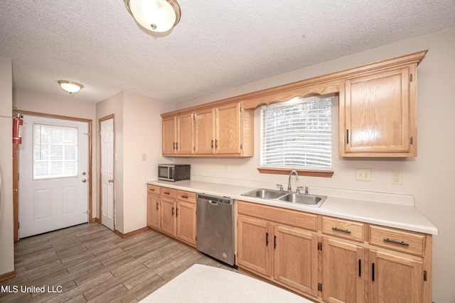 kitchen with stainless steel appliances, sink, light hardwood / wood-style flooring, and a textured ceiling