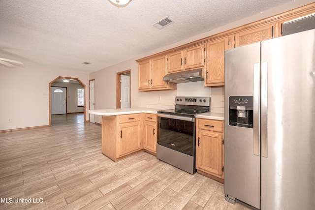 kitchen featuring stainless steel appliances, a textured ceiling, light wood-type flooring, kitchen peninsula, and light brown cabinets