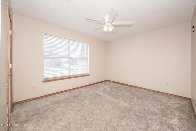 carpeted spare room featuring a textured ceiling and ceiling fan