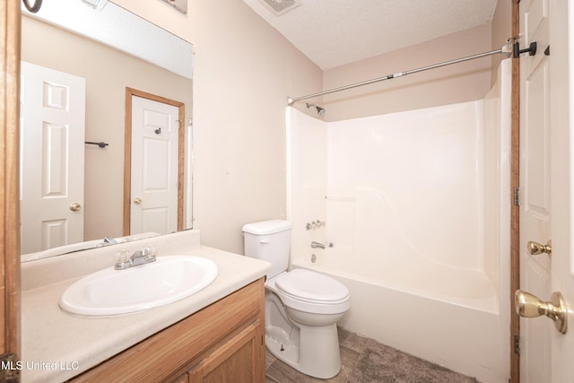 full bathroom with vanity, bathing tub / shower combination, a textured ceiling, and toilet