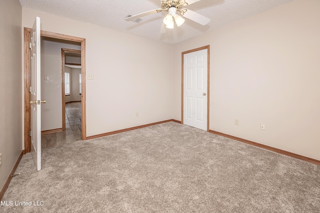 unfurnished bedroom featuring a closet, ceiling fan, light carpet, and a textured ceiling