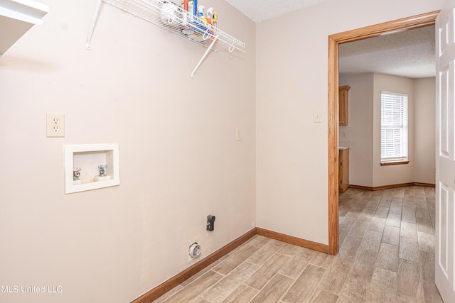 washroom with washer hookup, light hardwood / wood-style flooring, and a textured ceiling