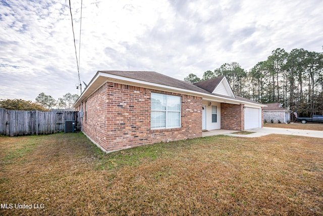 view of front of house with cooling unit, a garage, and a front yard