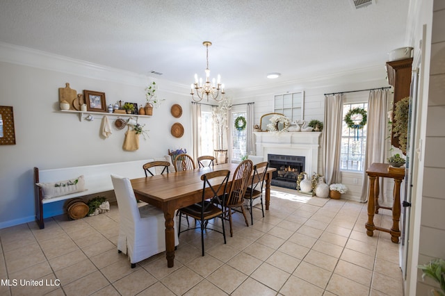 tiled dining area featuring a textured ceiling, an inviting chandelier, and crown molding