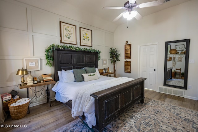 bedroom with hardwood / wood-style floors, ceiling fan, and vaulted ceiling