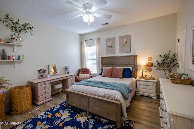 bedroom featuring ceiling fan, hardwood / wood-style floors, and a textured ceiling