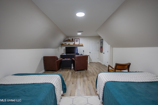 bedroom with vaulted ceiling and light wood-type flooring