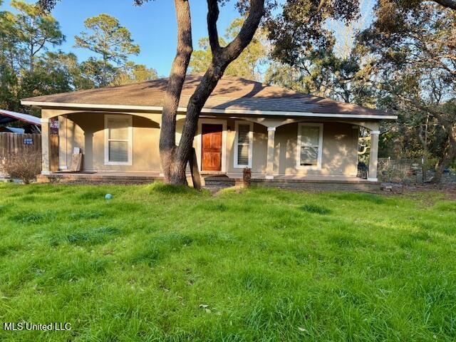 back of property with a yard and stucco siding