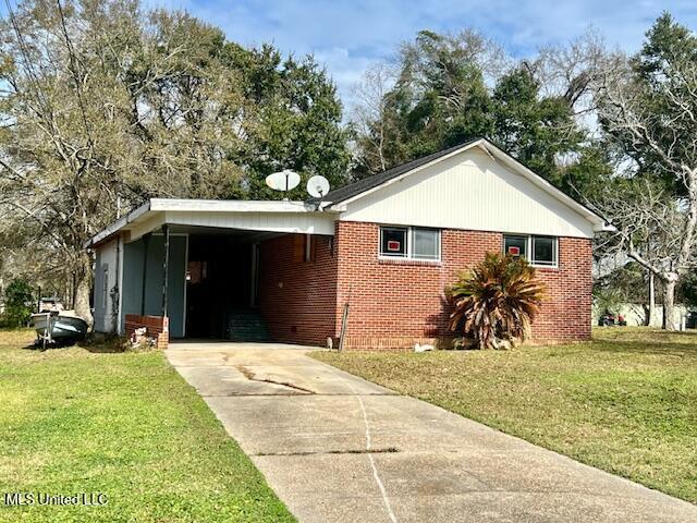 view of front of house with a carport and a front lawn