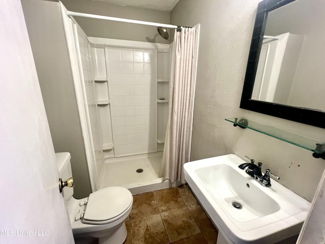 bathroom with toilet, sink, and a shower with curtain