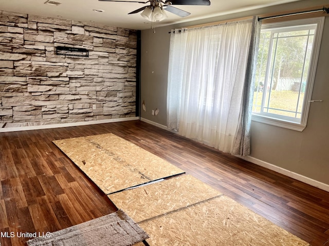 empty room featuring dark wood-type flooring and ceiling fan