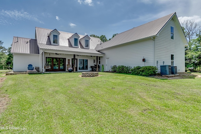 back of house featuring french doors, central AC, a yard, and metal roof
