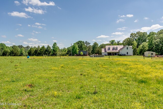 view of yard with fence and a rural view